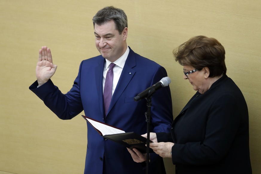 Bavarian State Governor Markus Soeder takes the oath of office after he was elected for his first term besides parliament president Barbara Stamm in the Bavarian parliament in Munich, Germany, Friday, ...