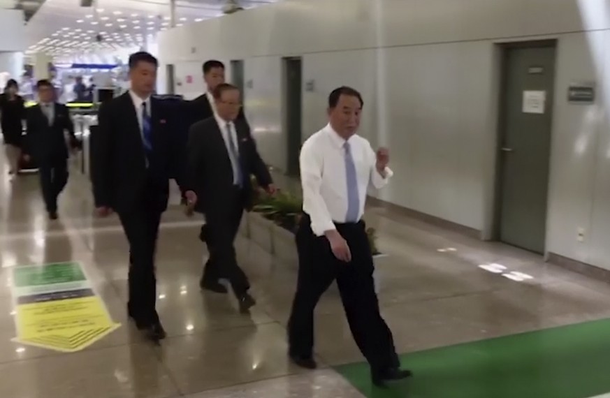 In this image made from video, Kim Yong Chol, in white, a former military intelligence chief who is now Kim Jong Un&#039;s top official on inter-Korean relations, walks upon arrival at Beijing airport ...