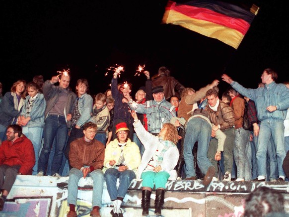 ARCHIVE --- VORSCHAU 30. JAHRESTAG MAUERFALL BERLIN AM 9. NOVEMBER 2019 --- A picture dated 09 November 1989 shows people celebrating the opening of the inner-German border with sparklers on Berlin Wa ...