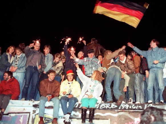 ARCHIVE --- VORSCHAU 30. JAHRESTAG MAUERFALL BERLIN AM 9. NOVEMBER 2019 --- A picture dated 09 November 1989 shows people celebrating the opening of the inner-German border with sparklers on Berlin Wa ...