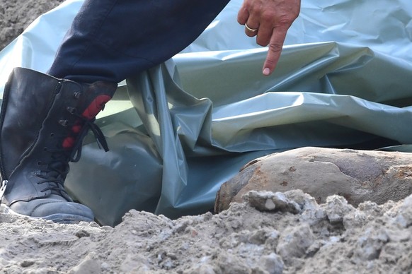 epa07648343 A police bomb disposal expert points at a WWII bomb discovered on a construction site close to the Alexanderplatz, in Berlin, Germany 14 June 2019. According to Berlin Police the 100 kilog ...