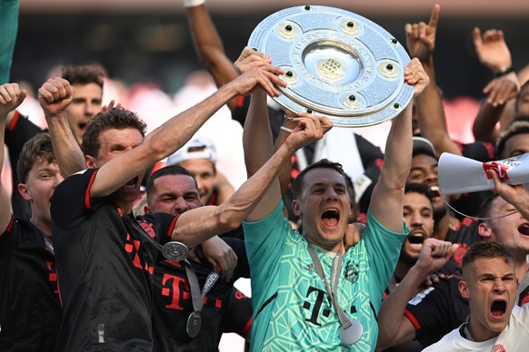 epa10657860 Thomas Mueller (L) and Manuel Neuer (R) of Munich lift the league title trophy after winning the German Bundesliga soccer match between 1.FC Cologne and FC Bayern Munich, in Cologne, Germa ...