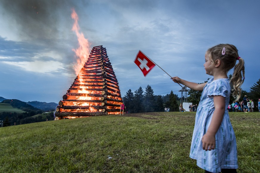 Ein Maedchen schwenkt die Schweizerfahne an der Bundesfeier der Gemeinde Fischenthal ZH mit einem der groessten Hoehenfeuer in der Schweiz. Dienstag 1. August 2017. (KEYSTONE/Christian Merz)