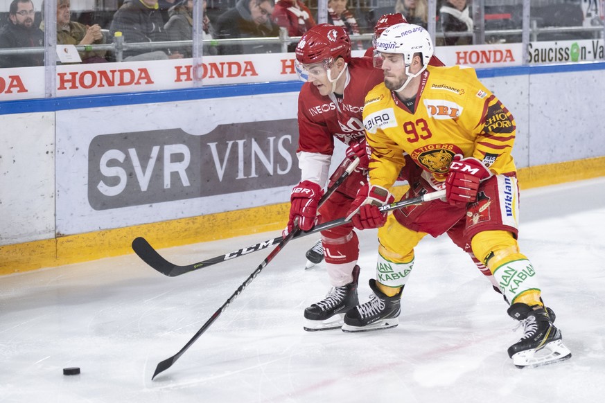 L&#039;attaquant lausannois Robin Leone, gauche, lutte pour le puck avec l’attaquant de Langnau Nolan Diem, droite, lors du premier match du quart de finale de play off du championnat suisse de hockey ...