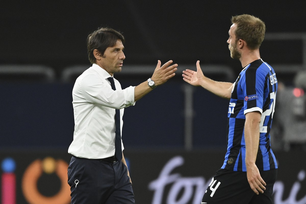 Inter Milan's head coach Antonio Conte clasps hands with Inter Milan's Christian Eriksen during the Europa League round of 16 soccer match between Inter Milan and Getafe at the Veltins-Arena ...