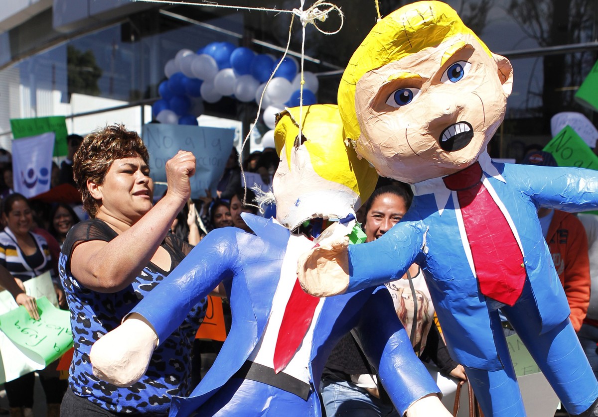 epa05736448 Demonstrators brake a Donald Trump doll during a protest against US President Donald Trump's inauguration ceremony, in front of a US Ford dealer in Mexico City, Mexico, 20 January 201 ...