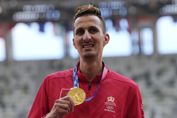 Soufiane El Bakkali, of Morocco, holds his gold medal on the podium for the men&#039;s 3000-meters steeplechase at the 2020 Summer Olympics, Tuesday, Aug. 3, 2021, in Tokyo. (AP Photo/Francisco Seco)