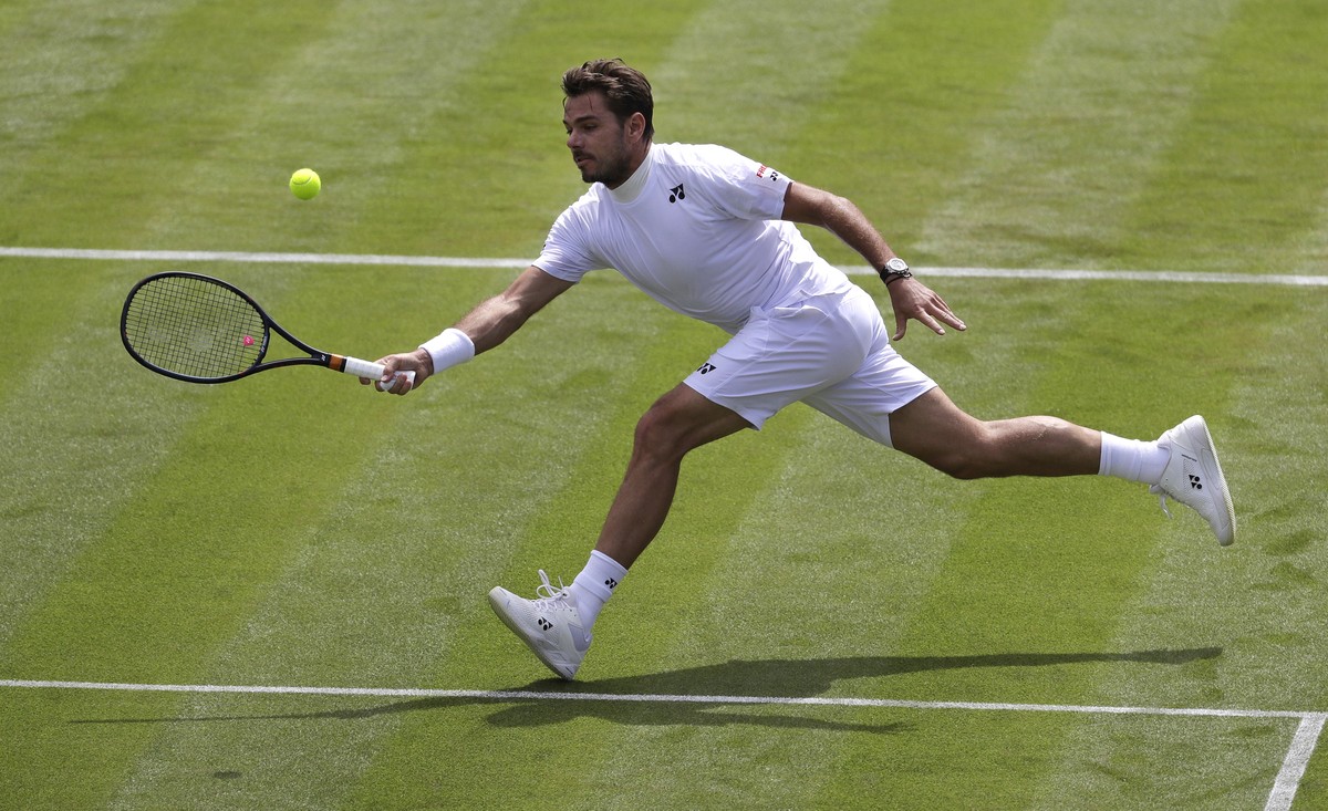 Switzerland's Stan Wawrinka returns to Belgium's Ruben Bemelmans during their Men's singles match on day one of the Wimbledon Tennis Championships in London, Monday, July 1, 2019. (AP P ...