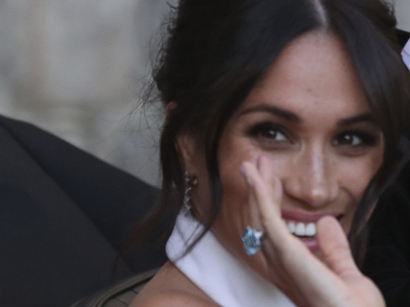 The newly married Duke and Duchess of Sussex, Meghan Markle and Prince Harry, leave Windsor Castle in a convertible car after their wedding in Windsor, England, to attend an evening reception at Frogm ...