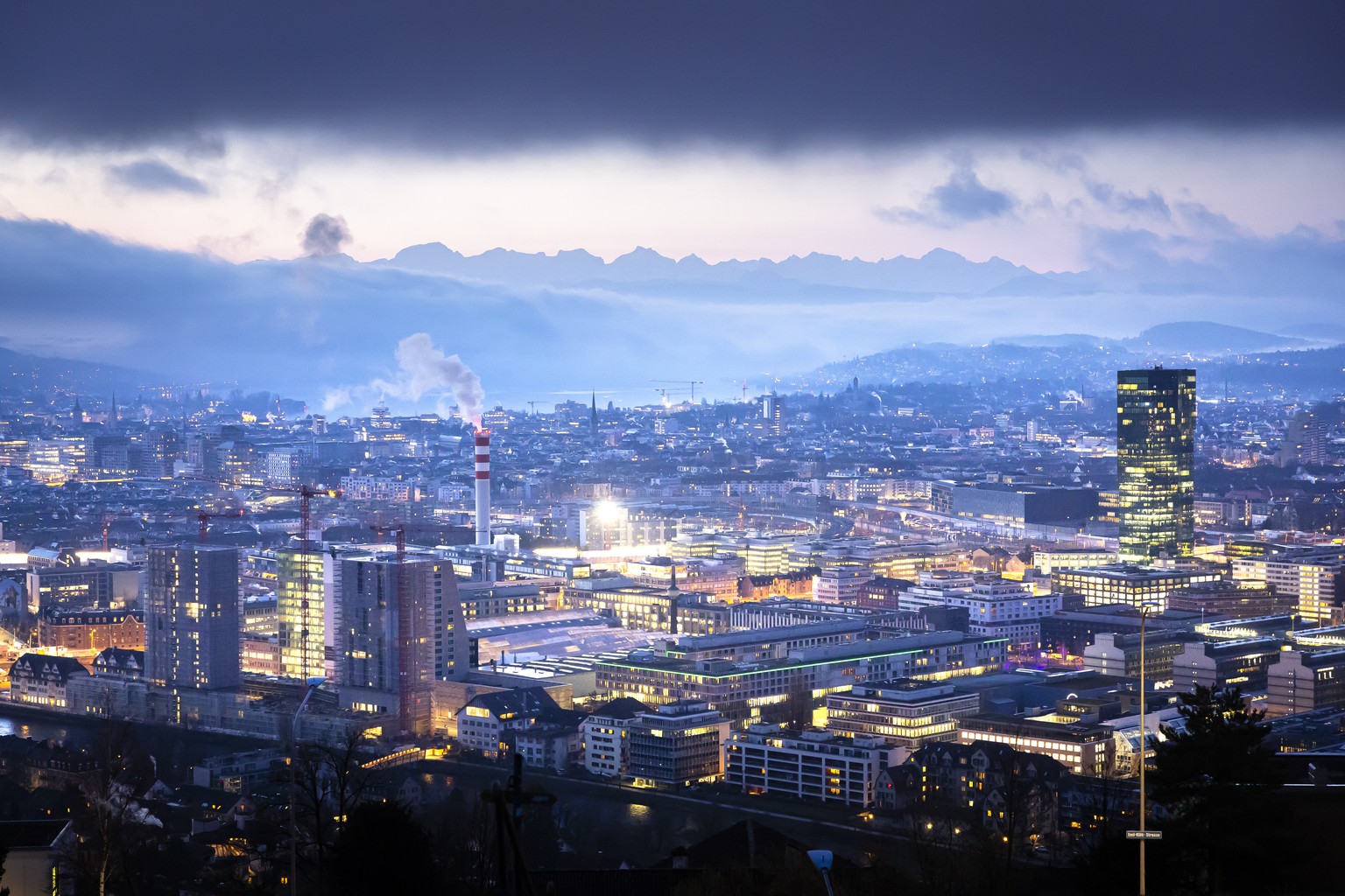 Die Stadt Zuerich mit dem Zuerichsee, hinten, und dem Primetower, rechts, von der Waid auf dem Hoenggerberg am fruehen Morgen in der Daemmerung, am Montag, 5. Februar 2024 in Zuerich. (KEYSTONE/Michae ...