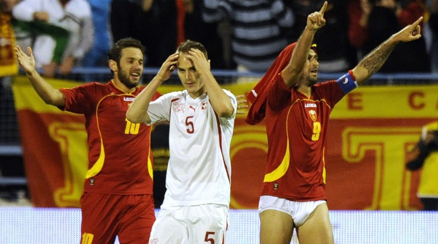 Montenegro forward Radomir Djalovic, left, and Montenegro forward Mirko Vucinic, right, celebrate the first goal in front of Swiss defender Steve Von Bergen, center, during the Euro 2012 group G quali ...
