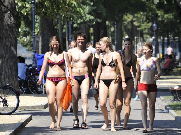 Junge Leute spazieren an der Rheinpromenade nach einem erfrischenden Bad im Rhein bei heissen Sommertemperaturenam, am Donnerstag, 20. August 2009 in Basel. (KEYSTONE/Georgios Kefalas)