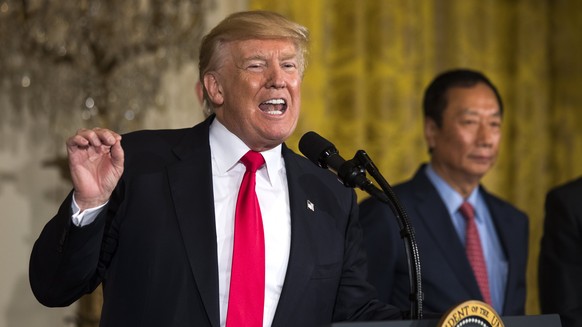 epa06111586 U.S. President Donald J. Trump (L) speaks about the opening of a Foxconn plant in Wisconsin, while Terry Gou (R), Foxconn's founder and chairman, looks on in the East Room...