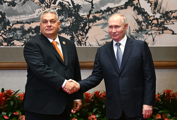 epa10923359 Hungarian Prime Minister Viktor Orban (L) and Russian President Vladimir Putin shake hands before their meeting as part of the 3rd Belt and Road Forum at the Diaoyutai State Guest House in ...