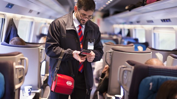 ZUR EINFUEHRUNG DES SWISSPASSES VOR DREI MONATEN STELLEN WIR IHNEN HEUTE, MITTWOCH, 4. NOVEMBER 2015, FOLGENDES NEUES BILDMATERIAL ZUR VERFUEGUNG --- Conductor Salvatore Grade verifies a train passeng ...