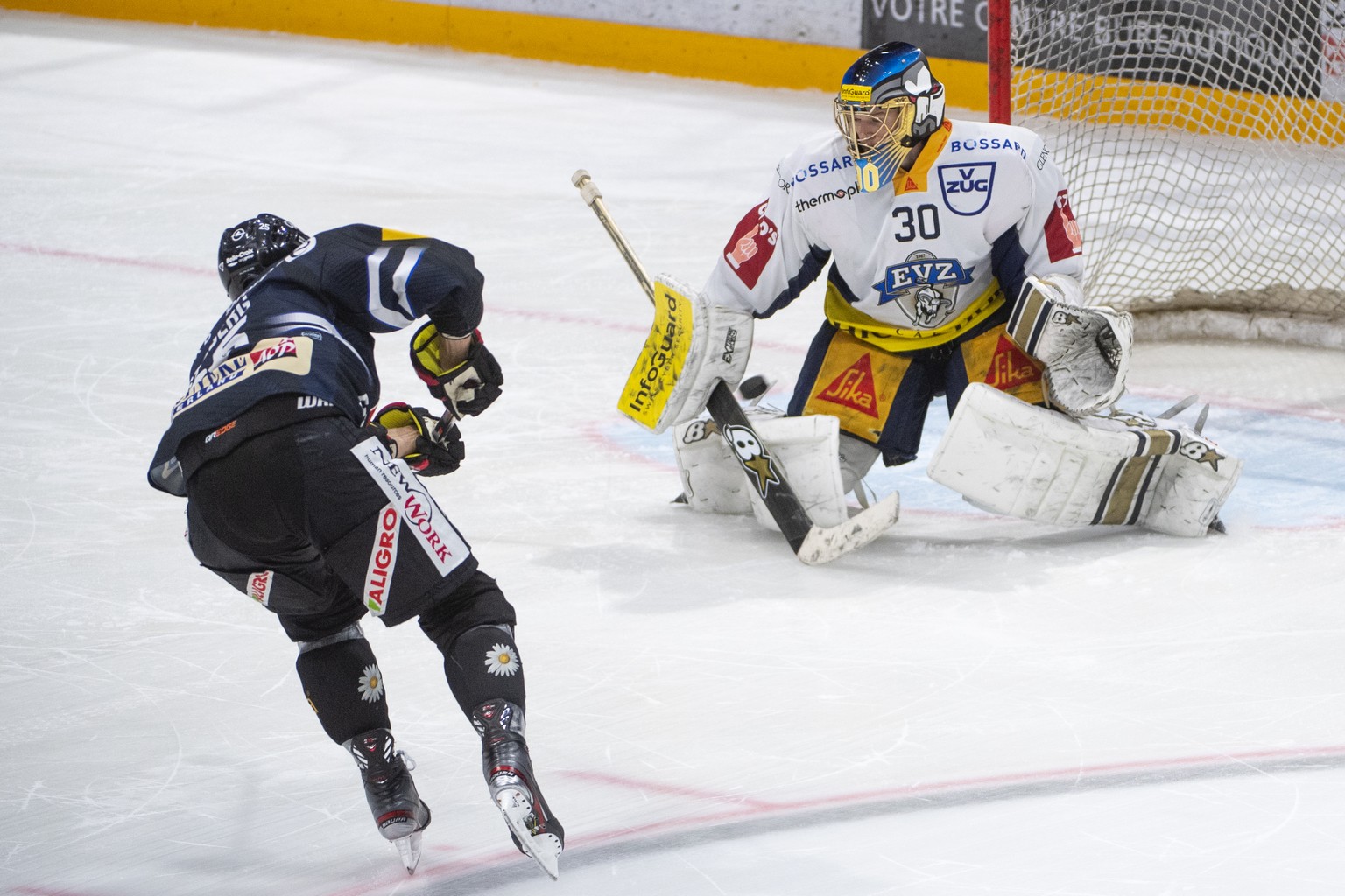 Fribourgs, Viktor Stalberg, links, erzielt das Siegestor, gegen Zugs Goalie, Leonardo Genoni, waehrend dem Meisterschaftsspiel der National League, zwischen dem HC Fribourg-Gotteron und dem EV Zug, am ...