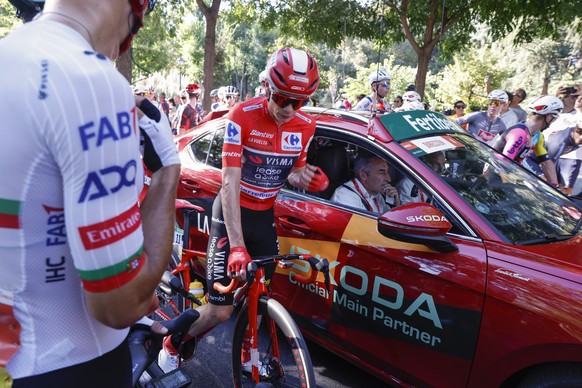 epa12376882 Overall leader, Danish rider Jonas Vingegaard (C) of Visma team, and cyclists wait as pro-palestine protesters disrupt the route during the 21st and last stage of La Vuelta a Espana cyclin ...