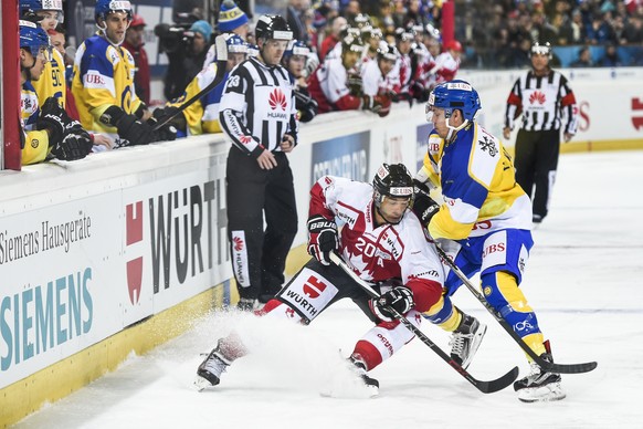 Team Canada&#039;s Manny Malhorta, left, fights for the puck with Davos&#039; Perttu Lindgren, during the game between Team Canada and Switzerland&#039;s HC Davos, at the 89th Spengler Cup ice hockey  ...
