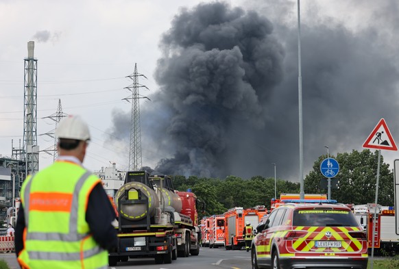 27.07.2021, Nordrhein-Westfalen, Leverkusen: Einsatzfahrzeuge der Feuerwehr stehen unweit einer Zufahrt zum Chempark