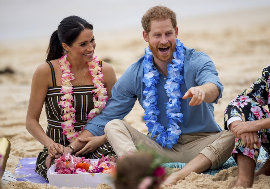 FILE - In this Friday, Oct. 19, 2018 file photo Britain's Prince Harry and Meghan, Duchess of Sussex meet with a local surfing community group, known as OneWave, raising awareness for mental health an ...