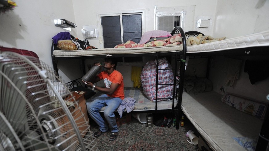 epa03955192 An Amnesty International handout photo dated 2012 shows a migrant worker sitting on a bunk bed in his accommodation in Qatar. Amnesty International on 17 November 2013 released a report bl ...