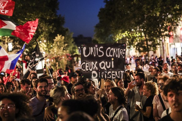 epa11466009 People react after the announcement of the results of the second round of the French legislative elections, in Marseille, southern France, 07 July 2024. Banner in picture reads &#039;Unite ...