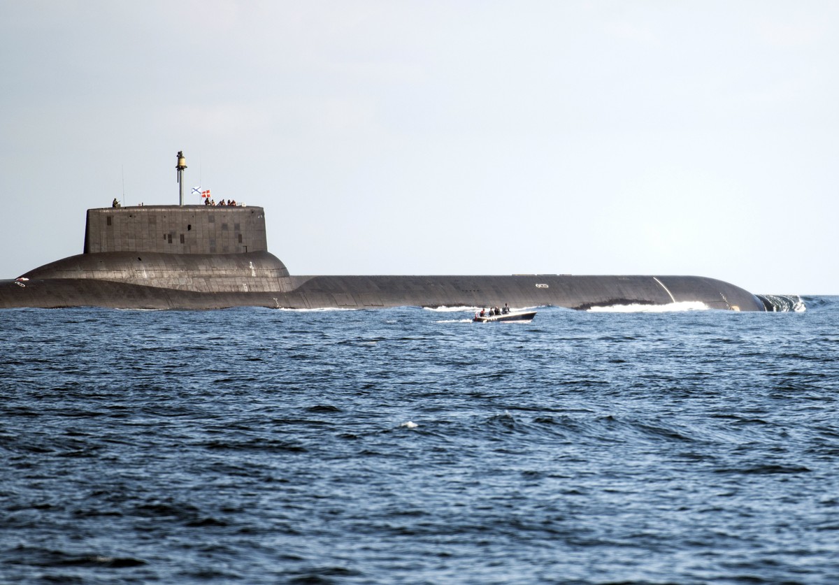epa06102132 A small motorboat makes its way as the Russian 'Thyphoon'-class nuclear submarine 'Dmitrij Donskoj' ploughs through Danish waters while reportedly being on its way to S ...