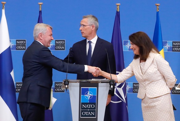Finnlands Aussenminister Pekka Haavisto und die schwedische Aussenministerin Ann Linde schütteln sich vor Nato-Generalsekretär Jens Stoltenberg die Hände.