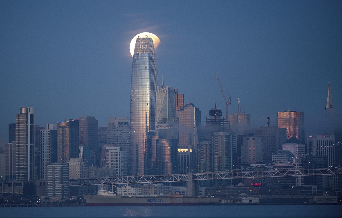 A partially-eclipsed super blue blood moon sets behind the Salesforce Tower on Wednesday, Jan. 31, 2018, in San Francisco. It's the first time in 35 years a blue moon has synced up with a supermo ...