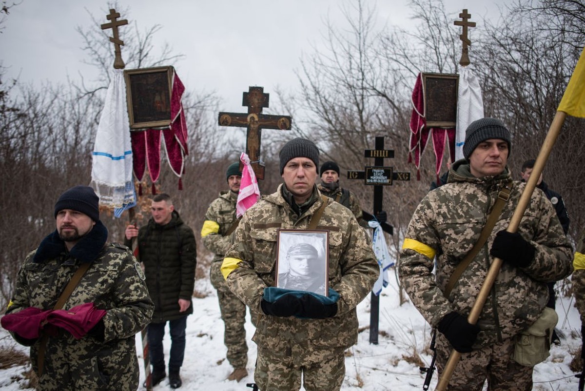 BILA KRYNYTSIA, UKRAINE - MARCH 6: Ukrainian soldiers are holding the portrait and the medals of Denys Hrynchuk during the service at the cemetery in Bila Krynytsia, on March 6, 2022 in Chernivtsi reg ...