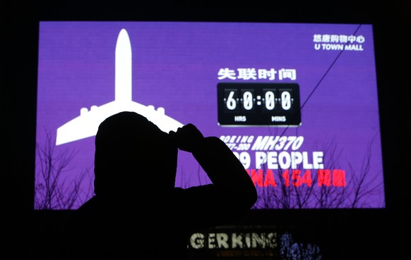A woman looks on in front of a giant screen showing the hours since Malaysia Airlines flight MH370 went missing and the number of passengers onboard, including 154 Chinese people, at a shopping mall, in Beijing March 10, 2014. The disappearance of a Malaysian airliner about an hour into a flight to Beijing is an "unprecedented mystery", the civil aviation chief said on Monday, as a massive air and sea search now in its third day failed to find any trace of the plane or 239 people on board. REUTERS/Jason Lee (CHINA - Tags: DISASTER TRANSPORT)