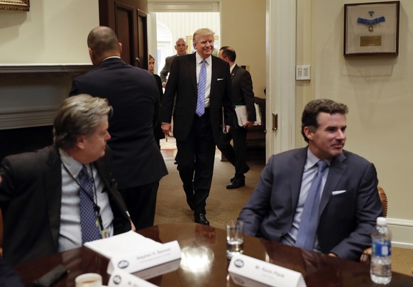 FILE - In this Jan. 23, 2017, file photo, President Donald Trump smiles as he walks in from the Oval Office of the White House in Washington, to host breakfast with business leaders in the Roosevelt R ...