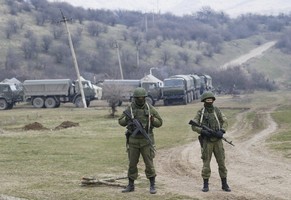 epa04121666 Armed men in military uniform are seen outside the territory of Ukrainian military unit in the village of Perevalnoye, outside Simferopol, Ukraine, 12 March 2014. Crimea's secessionist authorities said on 12 March that they have partially closed the region's airspace to 