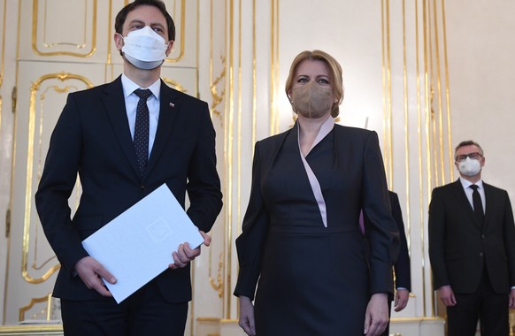 Slovak President Zuzana Caputova, right, poses with newly installed Prime Minister Eduard Heger, in Bratislava, Slovakia, on Thursday April 1, 2021. Slovakia