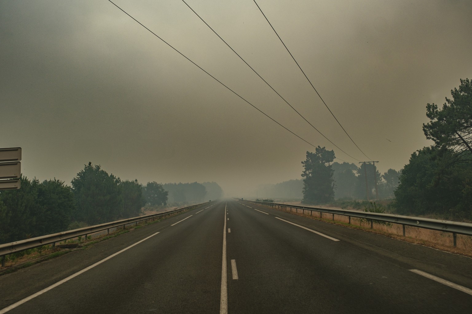 epa13131001 Smoke from a wildfire spreading on Cap Ferret peninsula is seen over a pine forest in Lege Cap-Ferret, south-western France, 24 July 2026. French Interior Minister Laurent Nunez confirmed  ...