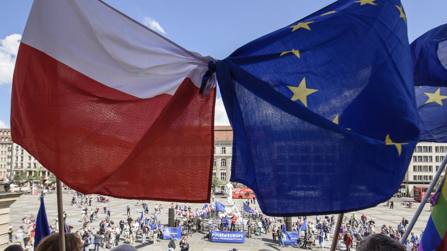 epa06128278 Participants of the monthly pro-European Union rally titled &#039;Pulse of Europe&#039;, hold flags in the national colors of Poland (L), and the European flag in front of the concert hall ...