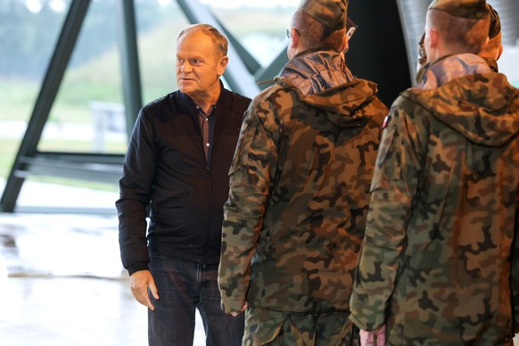 epa12368952 Polish Prime Minister Donald Tusk (L) meets air force personnel during a visit to the 32nd Tactical Air Base in Lask, Poland, 11 September 2025. Tusk thanked the pilots a day after the mil ...