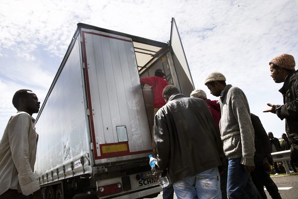 Flüchtlinge besteigen in Frankreich einen Lastwagen, der sie nach England bringen soll