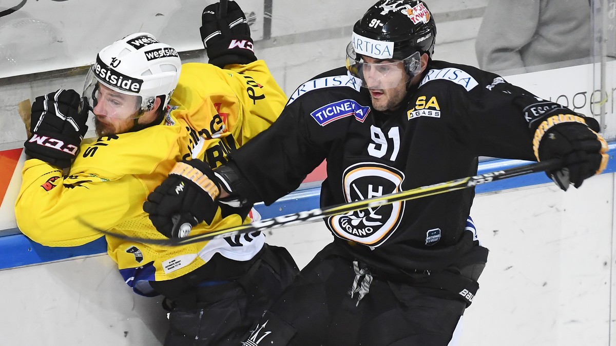 Bern's player Tristan Scherwey, left, fights for the puck with Lugano’s player Julian Walker, right, during the preliminary round game of National League Swiss Championship 2017/18 between HC Lug ...