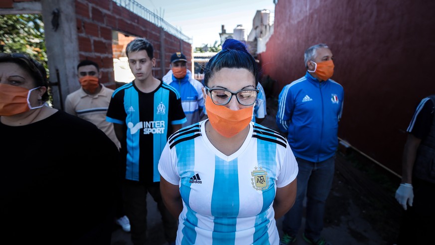 epaselect epa08339710 People wait for food delivered by members of the Argentina Army at Rafael Castillo neighborhood in Buenos Aires, Argentina, 02 April 2020. The Argentinian Army delivered three th ...