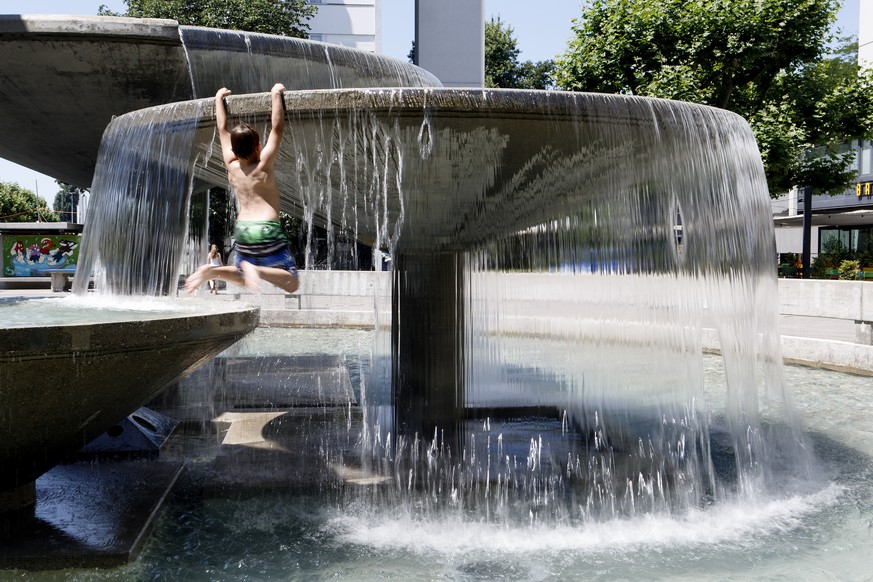 A little boy enjoys a cool off in the water of a fountain, during a heatwave, in Carouge near Geneva, Switzerland, Sunday, July 10, 2016. (KEYSTONE/Salvatore Di Nolfi)