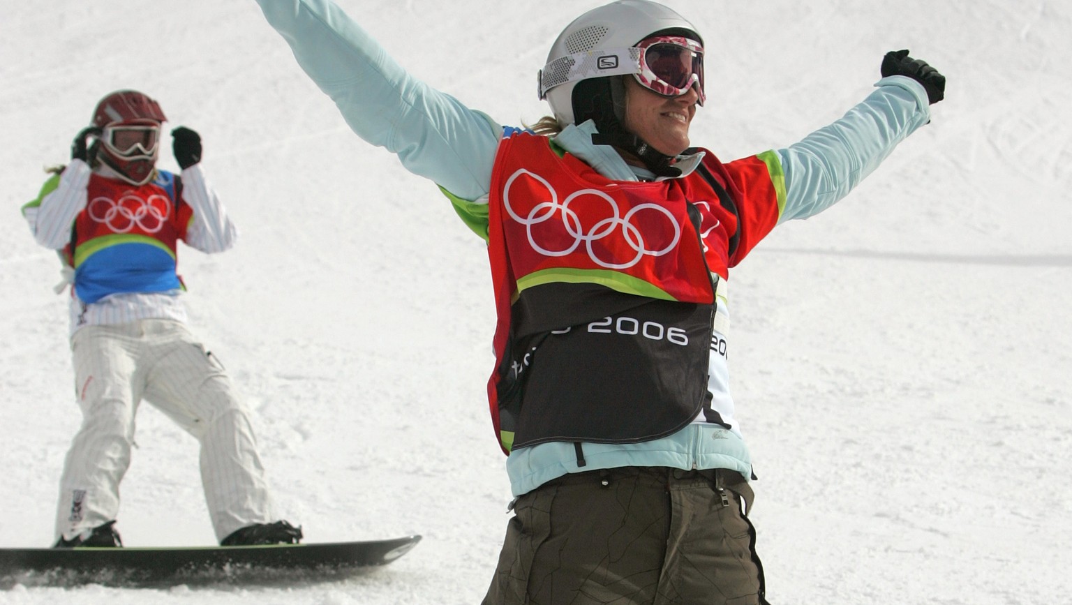 Tanja Frieden of Switzerland reacts after winning a gold medal, as American Lindsey Jacobellis, rear, finishes second after crashing in sight of the finish line in the final of the Women&#039;s Snowbo ...