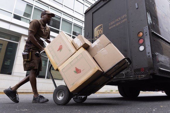 epa10904019 A UPS truck driver unloads boxes from a truck onto a dolly in Washington, DC, USA, 06 October 2023. The United States economy added 336,000 jobs in September 2023, according to a new jobs  ...
