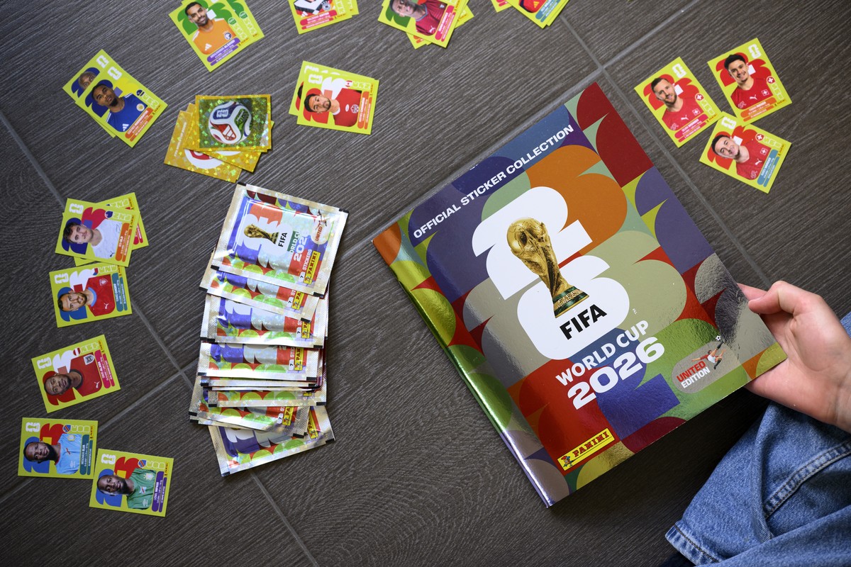epa12950699 A young collector opens a book before sticking Panini World Cup stickers of the Switzerland's soccer national team in the official Panini album of the FIFA World Cup 2026, in Lausanne ...