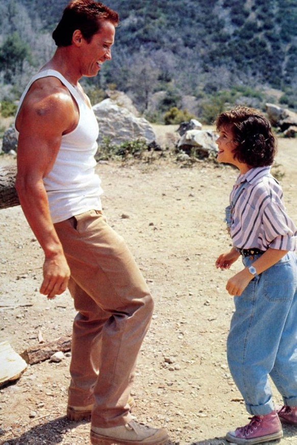 Arnold Schwarzenegger und Alyssa Milano am Set zu Commando, 1985.