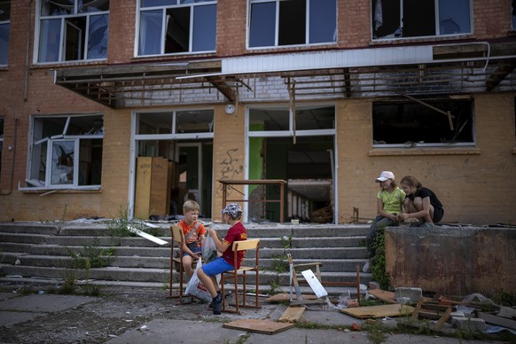 Children play outside their Chernihiv School #21, which was bombed by Russian forces on the 3rd of March, in Chernihiv, Ukraine, Tuesday, Aug. 30, 2022. Ukrainian children return to school without sha ...