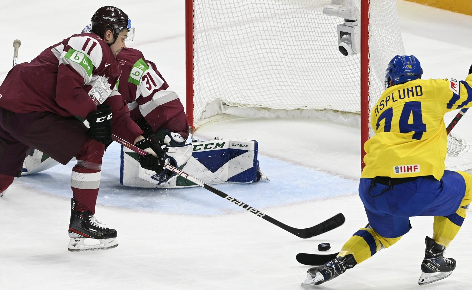 Rasmus Asplund, right, of Sweden tries to score during the 2022 IIHF Ice Hockey World Championships preliminary round group B match between Sweden and Latvia in Tampere, Finland, Tuesday May 24, 2022. ...