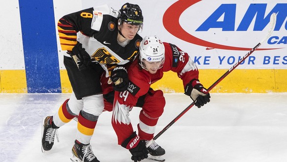 Germany&#039;s Tim Stutzle (8) checks Switzerland&#039;s Noah Meier (24) during the third period of an IIHF World Junior Hockey Championship game Wednesday, Dec. 30, 2020, in Edmonton, Alberta. (Jason ...