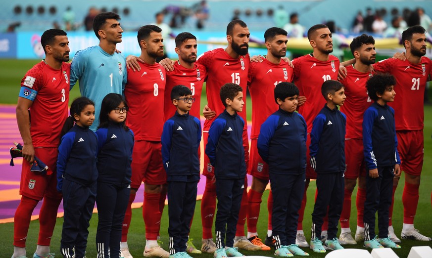 epaselect epa10317852 Players of Iran stand during their national anthem prior to the FIFA World Cup 2022 group B soccer match between England and Iran at Khalifa International Stadium in Doha, Qatar, ...