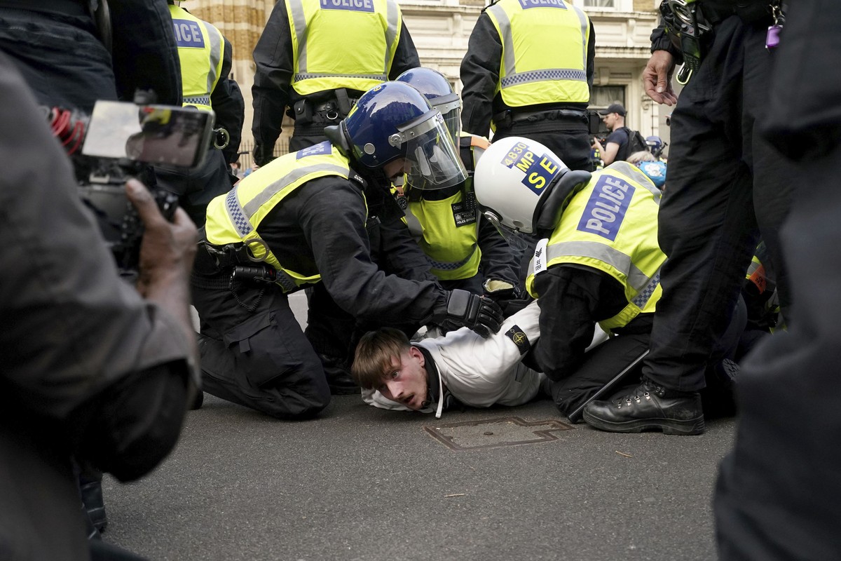 A protester is detained by police during the 'Enough is Enough' protest in Whitehall, London, Wednesday July 31, 2024, following the fatal stabbing of three children at a Taylor Swift-themed ...